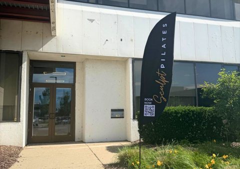 Sculpt Pilates Troy: Entrance of the Troy studio with a Sculpt Pilates flag banner