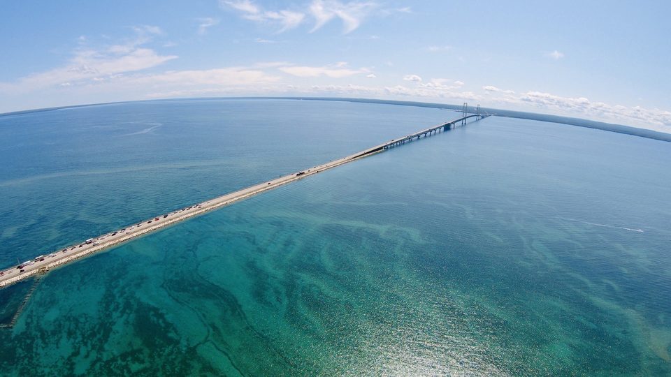 The Mackinac Bridge roadway from above, over turquoise water