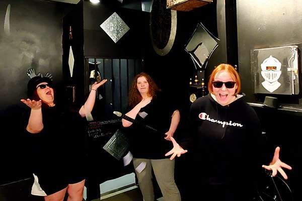 A team poses in a black and white illusion-themed room