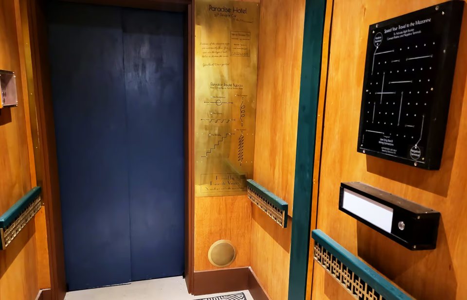 Dark blue elevator door and a wall control panel in a golden hallway set