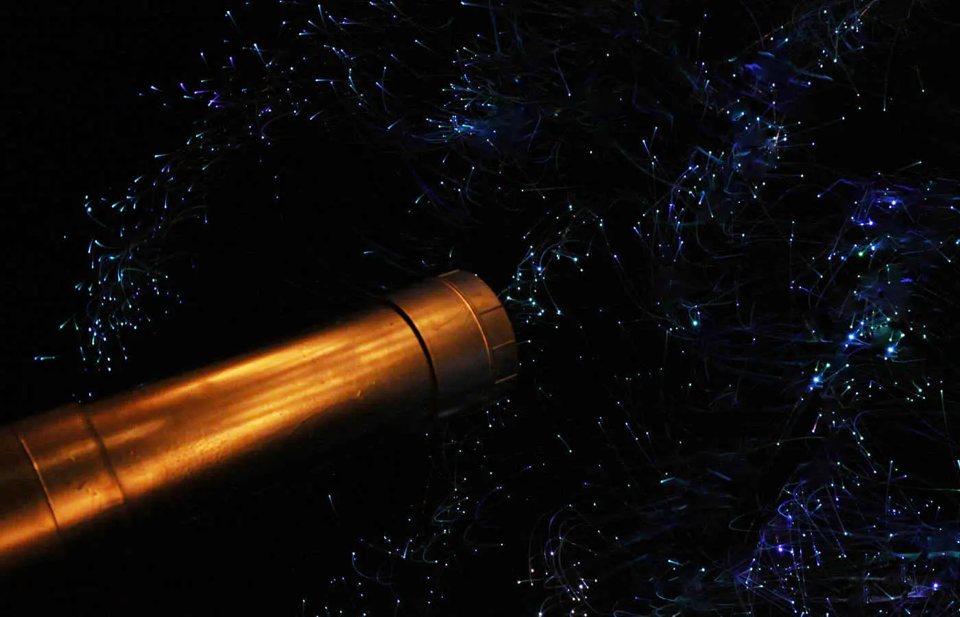 Brass telescope under a fiber-optic starry sky