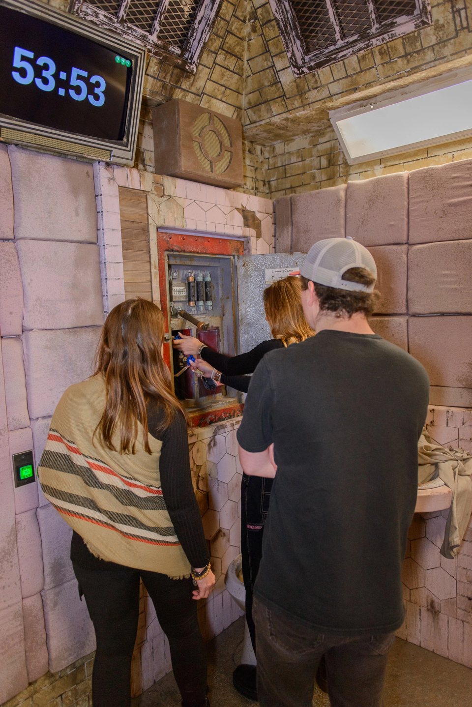 Players work on a fuse box in the padded cell under a countdown clock
