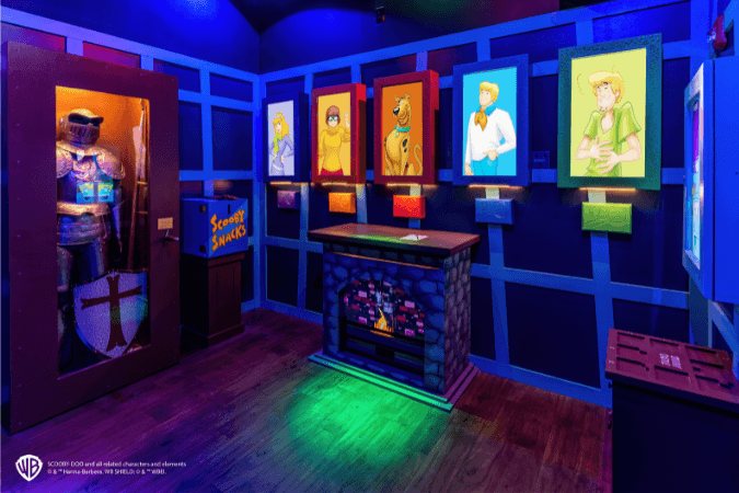 Scooby-Doo room with a suit of armor, portraits of the gang and a glowing fireplace