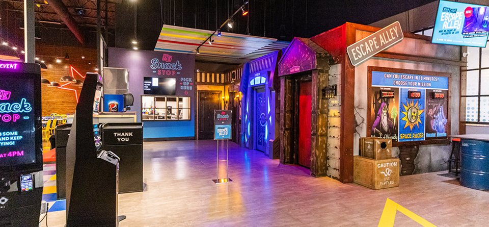 The Escape Alley area with themed room entrances, a mission board and a snack counter