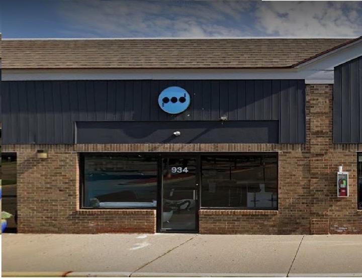 The Pod's brick storefront with the round blue logo above the entrance