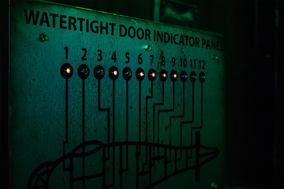 Green-lit submarine watertight door indicator panel with red and blue lights