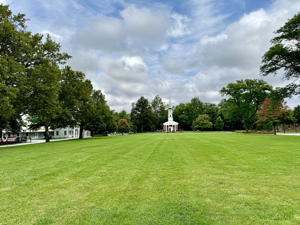 A Village Green, a falu központi gyepe, a túlsó végén a Martha-Mary kápolnával (2024)
