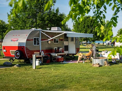 A camper trailer on a campsite under trees