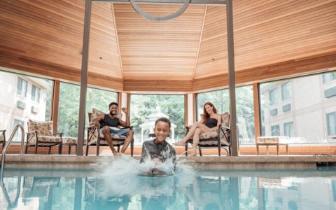 The indoor pool under a wood-paneled, many-sided ceiling