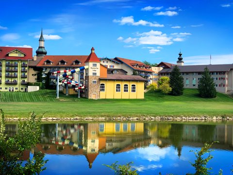 The lodge buildings and water slides on the waterfront, reflected in the water