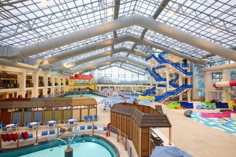 The indoor water park with a glass roof, pools and slides