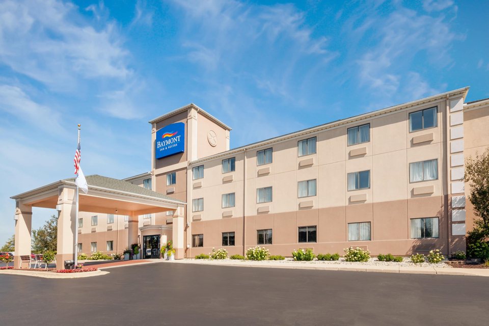 The beige hotel building with its covered drive-up entrance and Baymont sign