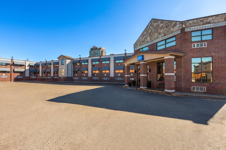 The brick hotel building and its parking lot under a blue sky