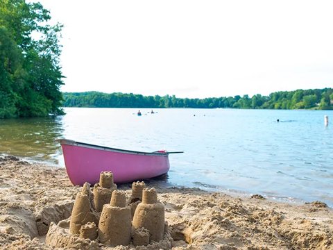 A sandy lakeshore with a boat