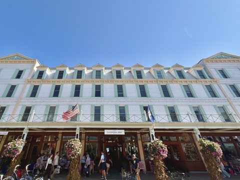 The hotel's white facade on Main Street with flower baskets and flags