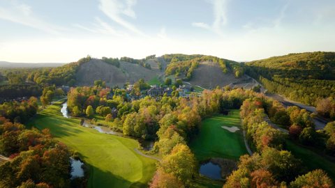 The resort's golf courses and wooded hills in an autumn aerial view