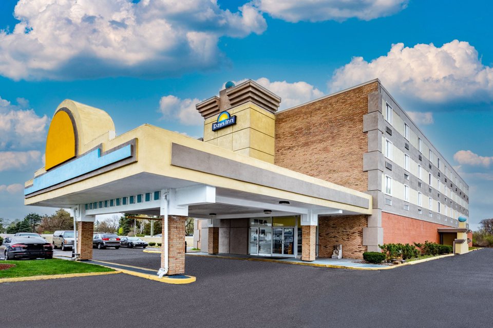 The hotel's drive-up canopy with the yellow sunburst and its brick building