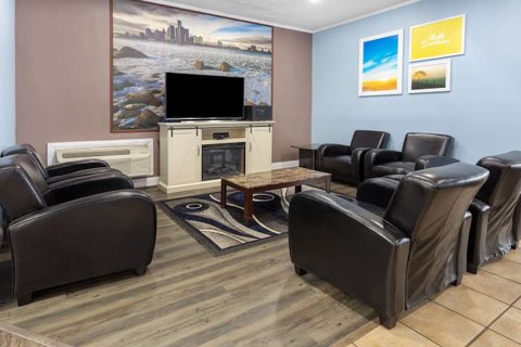 The lobby with black leather armchairs, a fireplace and a picture of the Detroit skyline
