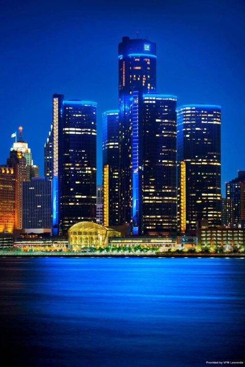 The Renaissance Center towers lit up at night, seen from across the Detroit River