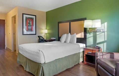A guest room with a large bed and a green wall