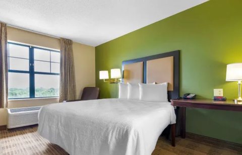 A guest room with a large bed and a green wall