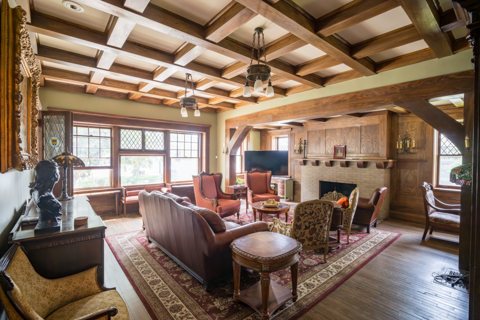 A parlor with a coffered wooden ceiling, a fireplace and a leather sofa