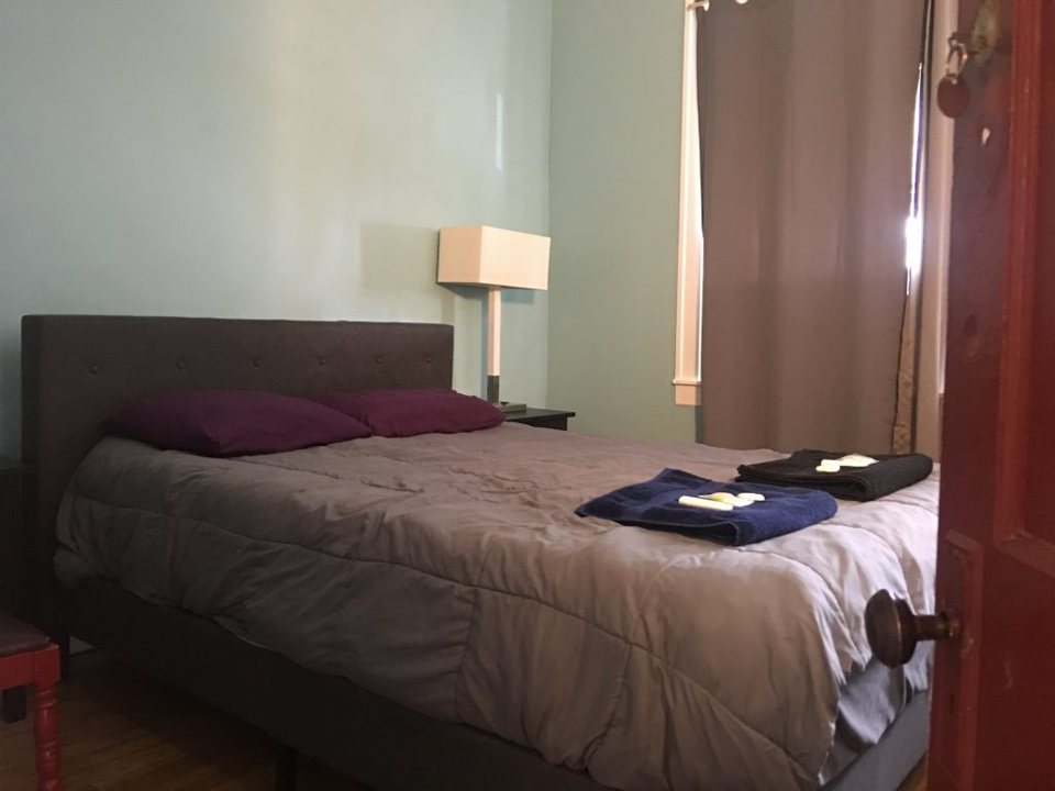 A private room with a double bed and folded towels
