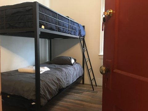 A room with a bunk bed and a wooden floor