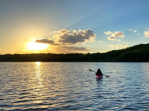 A kayaker on the lake at sunset