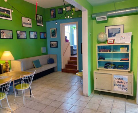 A common room with green walls, a table and shelves