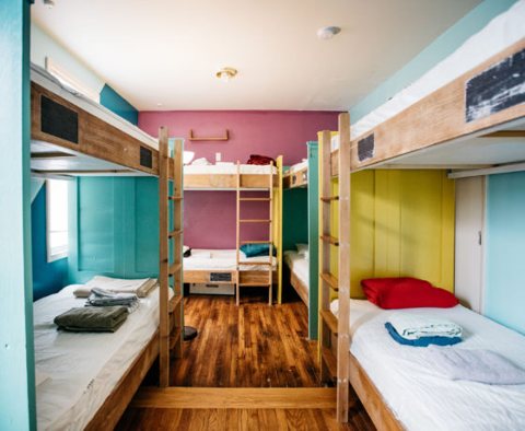 A dorm room with wooden bunk beds