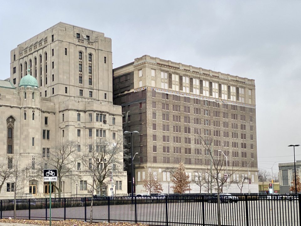 The former Fort Wayne Hotel with boarded-up windows at Cass Avenue and Temple Street in 2022, with the Masonic Temple on the left