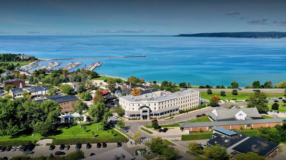Aerial view of the cream-colored Hotel Perry above Little Traverse Bay in Petoskey