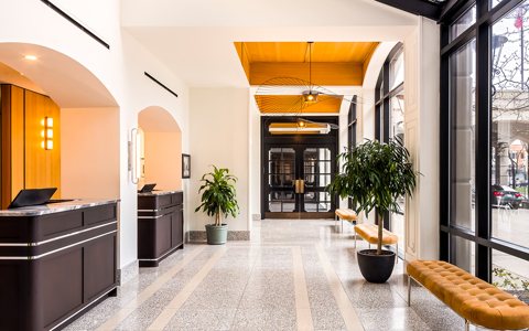 The front desk and a bright glass-walled corridor at the hotel entrance