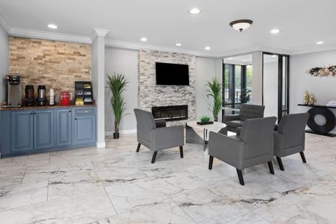 The lobby with gray armchairs, a stone fireplace wall and a coffee counter