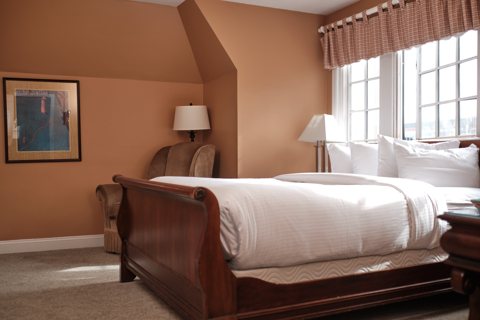 A guest room with a sleigh bed and large divided-light windows