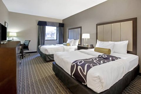 A guest room with two queen beds and a desk