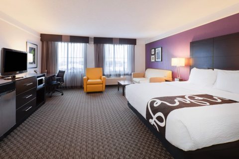 A guest room with a bed and an armchair