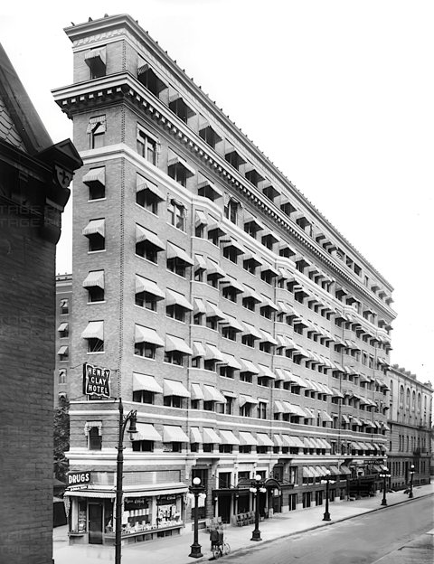 The Henry Clay Hotel, later the Milner, with striped window awnings and a corner tower in a black-and-white image from 1920
