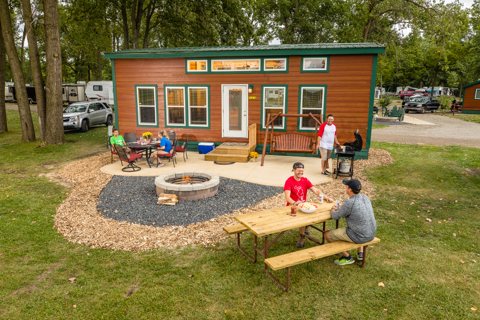 A small cabin with a fire pit and picnic table