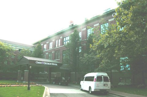 The hotel's covered entrance and shuttle van on the driveway in front of the brick building, 2008