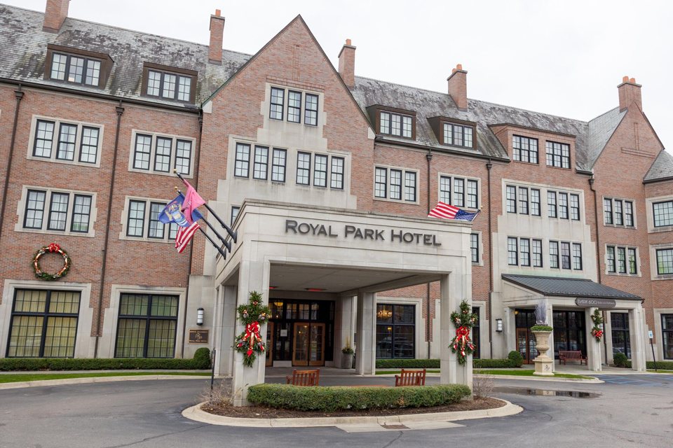 The Royal Park Hotel's brick facade and covered entrance with its name and flags in Rochester
