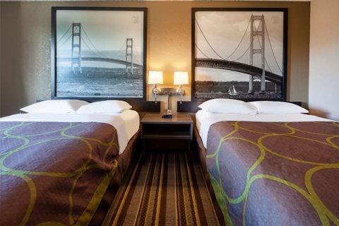 Room with two beds and a bridge photo on the wall