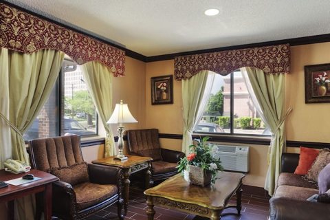 The lobby seating area with armchairs, a sofa and curtained windows