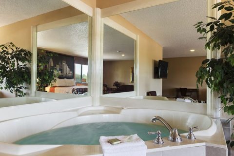 A suite with a whirlpool tub and a mirrored wall
