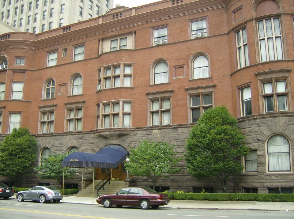 The Detroit Club's red brick clubhouse on a stone base with a canopied entrance