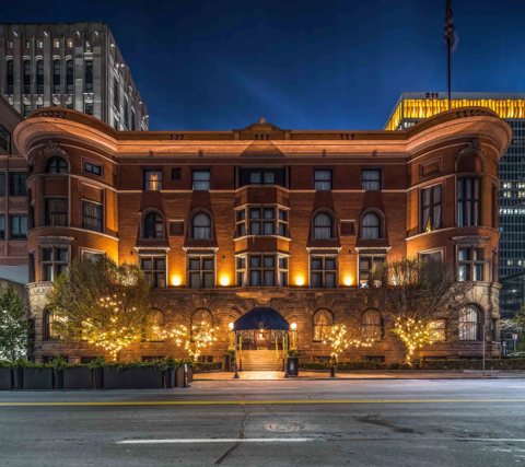 The lit clubhouse facade and entrance under an evening sky