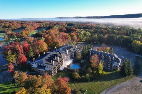 Aerial view of the resort's lodging buildings among autumn woods