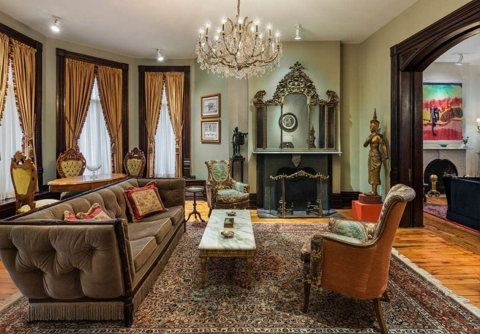 The parlour with a crystal chandelier, a fireplace and period furniture