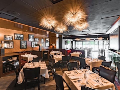 Set tables in the hotel restaurant with framed photos on the walls and pendant lights